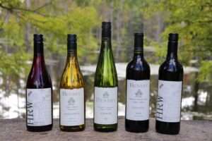 5 Bottles of wine sitting on a table in front of a vineyard at Hendry Ranch